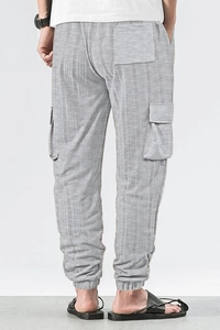 Detail of grey cargo pants showing breathable checkered fabric and side flap pocket