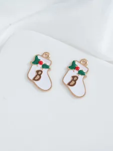 Macro view of white enamel Christmas stocking charms with holly leaves and letter B