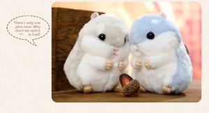 Close-up of cute grey and blue hamster plush pendants on a rustic wooden table