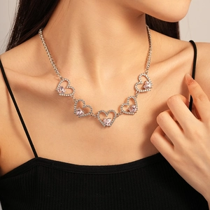 Detail of zircon hollow heart necklace with pink crystals on a silver chain