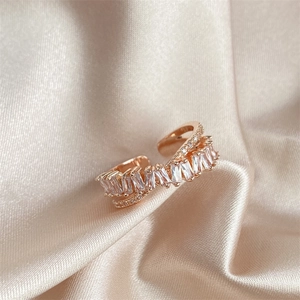 Detail of rose gold double-layered open ring with baguette zircon on silk fabric