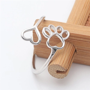 Minimalist silver open ring featuring hollow heart and dog paw prints on bamboo stand