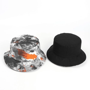 Detailed comparison of tie-dye artistic pattern and solid black reversible bucket hat