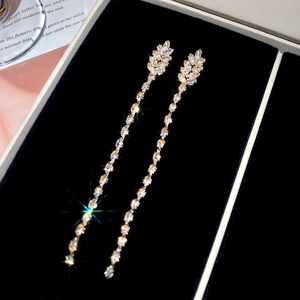 Macro view of 18K gold plated leaf fringe earrings with cubic zirconia in a jewelry box