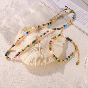 Set gioielli bohémien con perle d'acqua dolce e perline colorate su espositore corallo