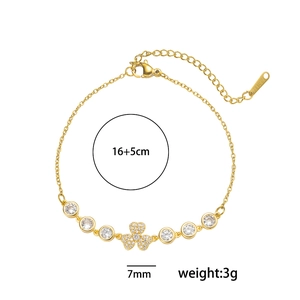 Détail d'un bracelet de 16+5cm en acier doré avec breloque cœur et fleur en zircon