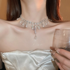 Detail of floral pearl necklace with sparkling rhinestones on model's neck