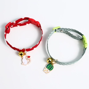 Close-up of adjustable pet collars with metal bells and colorful cactus charms