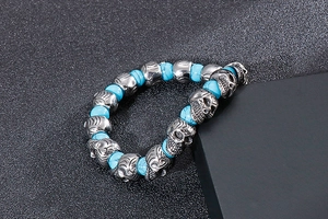 Close-up of vintage punk skull bracelet with blue turquoise beads on dark display box