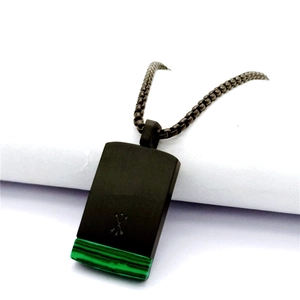 Macro shot of rectangular black metal pendant with green malachite texture inlay