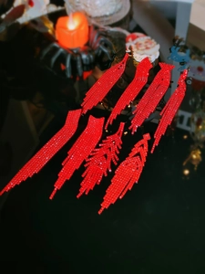 Close-up of sparkling red rhinestone tassel earrings with a festive holiday theme