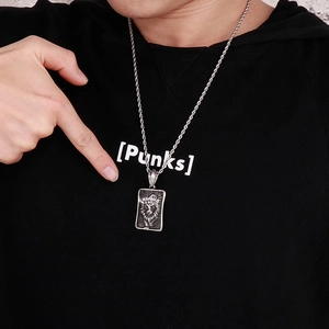 Détail du collier pendentif tête de lion en argent avec chaîne torsadée sur un sweat à capuche