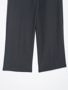 Close-up of the dark grey wide-leg trousers showing fabric texture and hem stitching