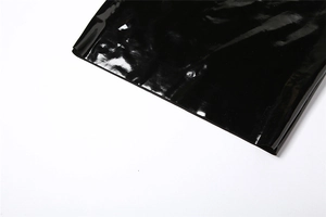Gros plan détaillé du tissu en similicuir noir brillant et des coutures de la jupe