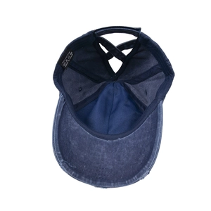 Distressed wash navy cotton baseball cap with criss-cross ponytail hole and frayed brim