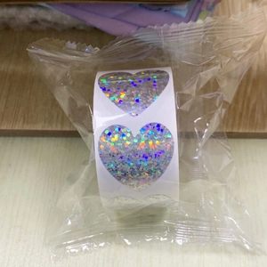 Macro detail of holographic silver laser heart stickers roll for gift packaging decoration