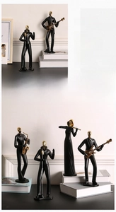 Détail de statues de musiciens en résine noir et or avec chanteur et joueur de guitare