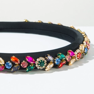 Macro detail of colorful crystal embellishments on a black satin Baroque headband