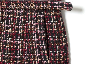 Detailansicht der Tweed-Textur in Rosa und Burgund mit Metallösen am Gürtel