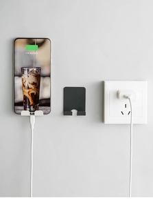 Wall-mounted phone holder with charging slot in black and white matte finishes