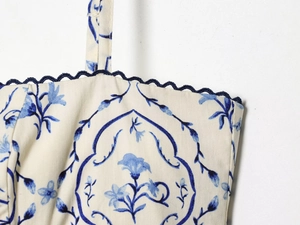 Detalle de vestido floral con ribete de encaje azul y tirantes finos de espagueti
