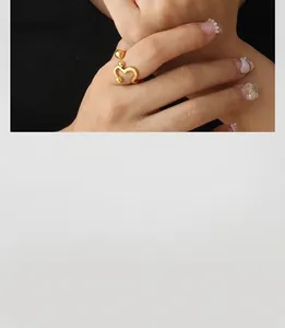 Detail of 18K gold irregular wavy ring featuring round beads on a minimalist band