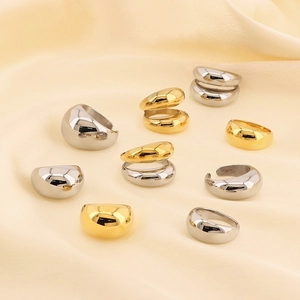 Polished 18k gold and silver dome rings displayed on elegant cream silk fabric