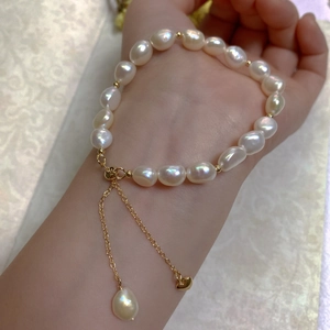 Close-up of Baroque freshwater pearl bracelet with adjustable gold chain on wrist