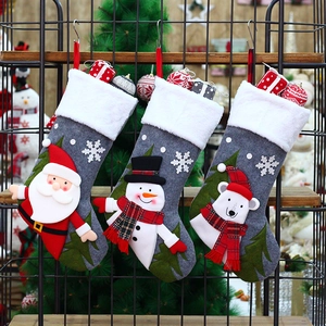 Three-piece Christmas stocking set featuring Santa, Snowman, and Polar Bear on metal rack