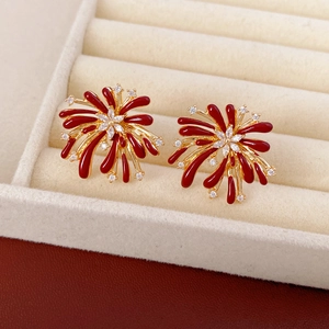 Gros plan détaillé des boucles d'oreilles fleurs rouges avec zircons sur plateau velours