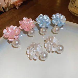 Elegant floral pearl earrings in pink, blue and cream on a ceramic jewelry tray