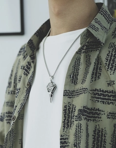 Viking raven skull pendant with Nordic runes on model wearing a green shirt