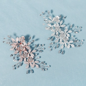 Close-up of rose gold and silver floral bridal hair clips with pearls and crystals