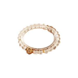 White crystal beaded bracelet featuring a gold hollow heart charm on a minimalist stand