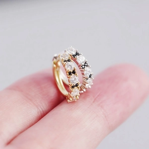 Macro view of gold and silver S925 sterling silver hoop earrings with black and white zircon