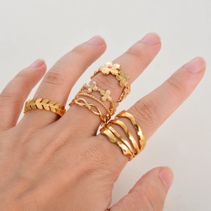 Gold stainless steel ring set with flower butterfly leaf and wave designs on hand