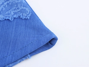 Gros plan détaillé du tissu denim bleu montrant les bords effilochés et les coutures