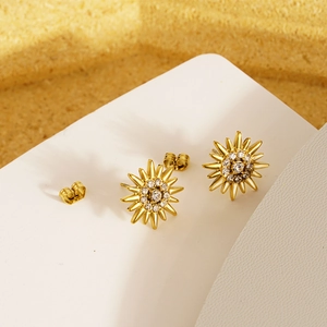 Elegant gold sunflower stud earrings with diamonds on a minimalist white display