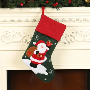 Linen Christmas stocking with Santa Claus embroidery hanging on a festive mantelpiece