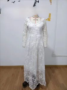 Detailed view of long sleeve white bridal gown with intricate floral embroidery and V-neckline