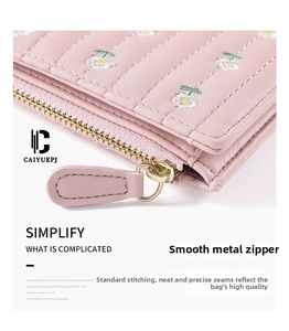 Detail of pink faux leather wallet with daisy embroidery and smooth gold zipper