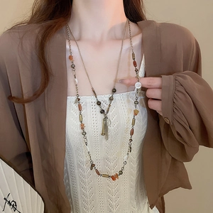 Dettaglio della collana vintage a più strati con perline, nappe metalliche e pietre