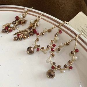 Detail of vintage bohemian tassel earrings and beaded teardrop hoops on ceramic plate