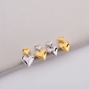 Two-tone gold and silver stainless steel heart dangle earrings with a polished mirror finish