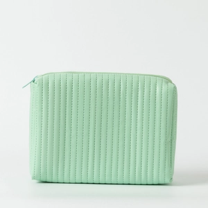 Detail view of mint green quilted leather makeup bag with vertical stitching and zipper