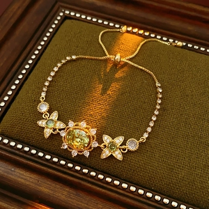 Détail du bracelet vintage doré avec pierre ovale jaune et accents floraux
