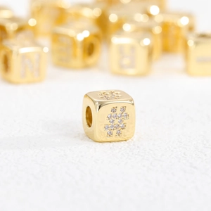 Macro view of a 18K gold-plated cube bead with zircon-set hash symbol detail