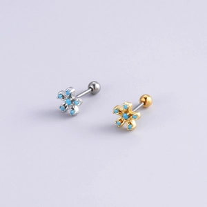 Détail de boucles d'oreilles fleur en argent et or avec turquoise et fermoir à vis