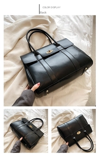 Detail view of large black leather tote bag featuring classic twist-lock metal buckle