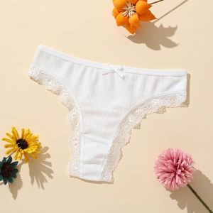 Vue détaillée du string côtelé blanc avec bordure en dentelle fine et petit nœud déco